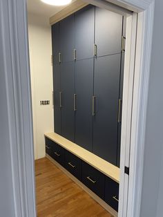 an empty room with blue cabinets and wooden floors