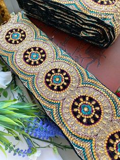 a close up of a tie on a table with flowers in the back ground and other items around it