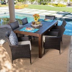 an outdoor dining table with chairs around it near a swimming pool and patio furniture set