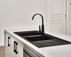 a black faucet sitting on top of a kitchen counter