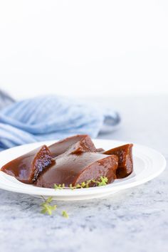 some food is on a white plate and next to a blue towel with green sprigs