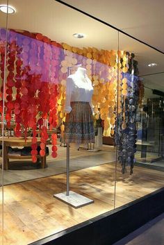 a display case with many different colored balloons in the front and behind it is a mannequin's head