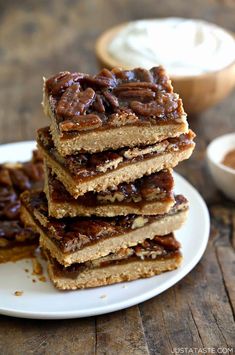 a stack of pecan bars sitting on top of a white plate