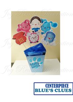 a blue cup with some paper cutouts on it and an animal themed centerpiece