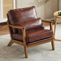 a brown leather chair sitting on top of a carpeted floor next to a table