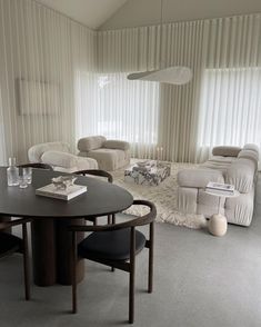 a living room filled with furniture and a round table in front of a large window