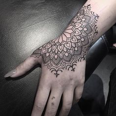 a woman's hand with a tattoo on it and a flower design on the palm