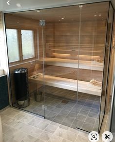 a sauna room with glass walls and tile flooring