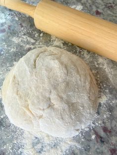 a ball of dough next to a rolling pin