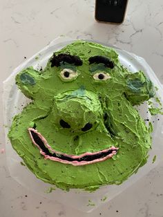 a cake with green frosting and a face on it