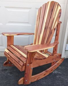 a wooden rocking chair sitting in front of a garage door with the seat made out of wood