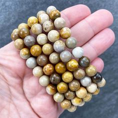 "Polished beads made from fossilized coral also known as coral jade. 8mm Bracelets Sized: 6.50\" - 7.00\" Our crystals and minerals are natural, and some are shaped by hand. Because each is unique and one of a kind, some may come with small chips or imperfections. Any appearances of cracks are one of the natural characteristics of this crystal or mineral and not because of damage. We select all crystals and minerals by hand. We choose the most unique and highest quality we can find. We try to ta Earthy Jasper Beaded Bracelets, Jasper Gemstone Beads Bracelet, Jasper Gemstone Beaded Bracelets, Beaded Jasper Bracelets With Gemstone Beads, Hand-strung Jasper Beaded Bracelets With Round Beads, Jasper Beaded Bracelets With Natural Stones, Healing Jasper Beaded Bracelets With 8mm Beads, Fossilized Coral, Glendale Az