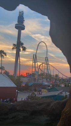 the sun is setting at an amusement park