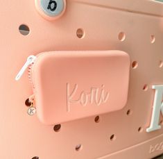 a pink suitcase with the word kori written on it's side and holes at the bottom