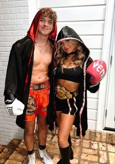 a man and woman dressed up in boxing gear standing next to each other on a brick floor