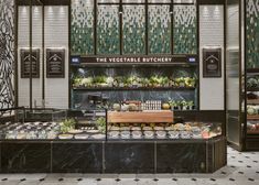 a display case filled with lots of fruits and veggies next to a wall