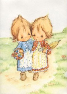 two children are standing together in the grass