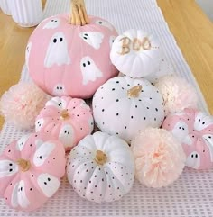 some pink and white pumpkins sitting on a table