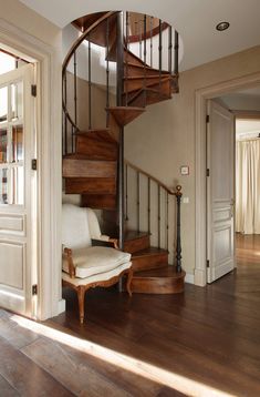 a spiral staircase in a home with wooden floors