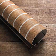 a roll of brown paper sitting on top of a wooden floor