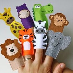 a hand holding several finger puppets with animals on them