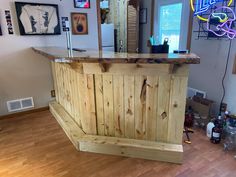 a bar made out of pallet wood in a room with pictures on the wall