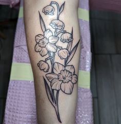 a black and white flower tattoo on the right leg, with flowers growing out of it