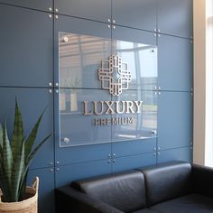 a black leather couch sitting in front of a blue wall with the words luxury premium written on it