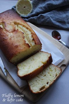 a loaf of lemon bread sitting on top of a cutting board next to a knife