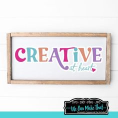 a sign that says creative with the words creative at heart on it, hanging from a wall