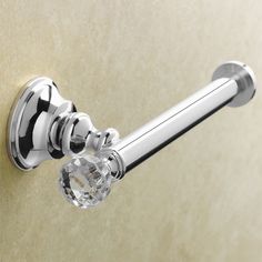 a chrome toilet paper holder with a crystal ball on the handle and an oval knob