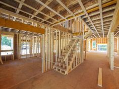 the inside of a house being built with wooden framing and ladders on the floor