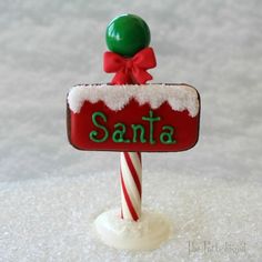 a candy cane with a santa sign on it