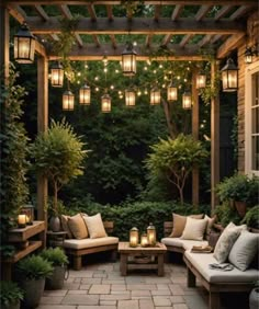 an outdoor seating area with lights strung from the ceiling and potted trees in the background