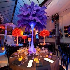 the table is set up with purple and orange centerpieces for an elegant event