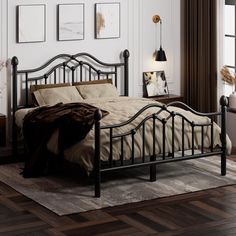 a metal bed frame in a bedroom with hardwood floors and white walls, along with pictures on the wall