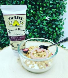 a bowl of oatmeal next to a cup of yogurt on top of a tree stump