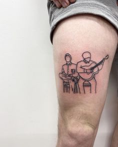 a man with a guitar tattoo on his leg next to another man playing the guitar