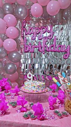 a pink birthday party with balloons and cake