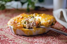 a close up of a casserole on a table with a spoon in it