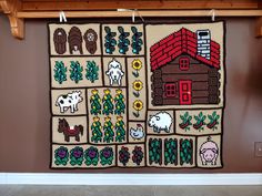 a wall hanging on the side of a building with farm animals and houses in it