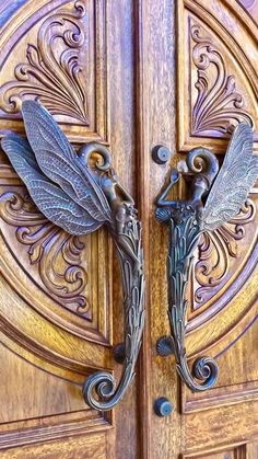 an ornate wooden door with two metal dragon handles