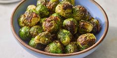 a blue bowl filled with brussel sprouts on top of a table