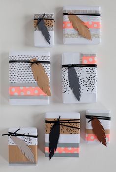 four wrapped gift boxes with feathers on them