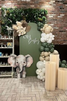 an elephant balloon display in front of a brick wall with greenery and balloons on it