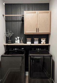 a washer and dryer in a small room with wood cabinets on the wall