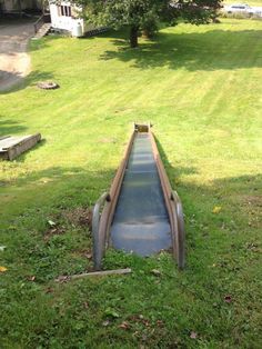 a long metal slide in the middle of some grass