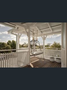 a white porch with a swing chair on it