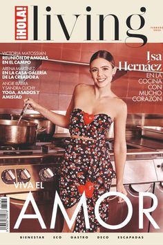 a woman standing in front of a stove on the cover of a magazine, wearing a floral dress