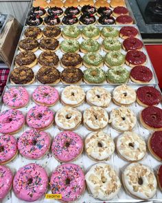 a display case filled with lots of different flavored donuts